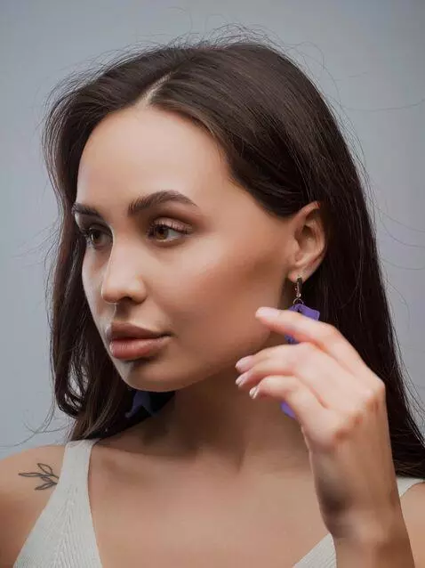 AI Video from prompt: add movement to the earrings; the model lightly 