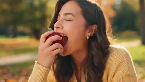 AI Video from prompt: a girl eat a apple happily