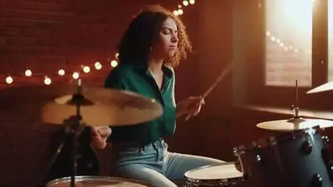 AI Video from prompt: She plays the drums. She bounces on her stool in