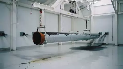 AI Video from prompt: In a clean, white workshop, an overhead crane ho