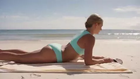 AI Video from prompt: A blonde woman sunbathing on the beach, she roll