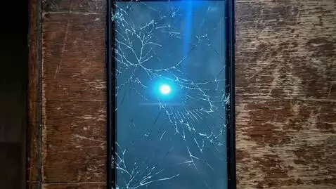 AI Video from prompt: Slow camera zoom in on the cracked screen. The b