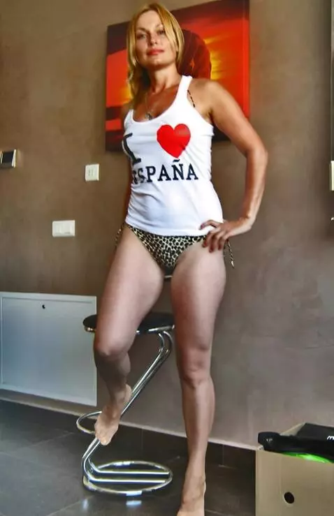 AI Video from prompt: a woman sitting on a barstool stands up, shifts 