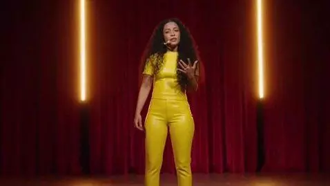 AI Video from prompt: A 19-year-old Colombian woman. She has a microph