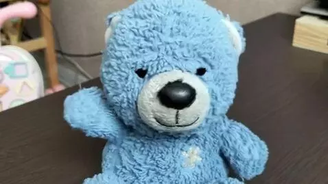 AI Video from prompt: The bear cub smiles, waves his paw hello and sta