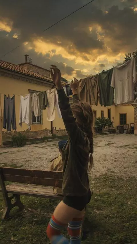 AI Video from prompt: A woman approaches a garment hanging on a line, 