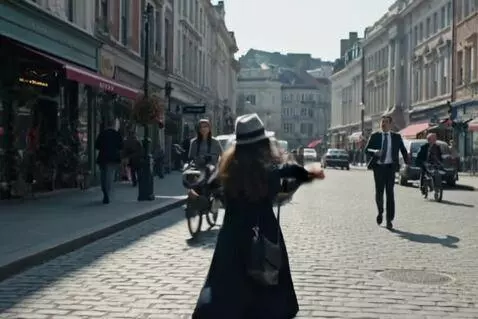 AI Video from prompt: A woman wearing a hat walks down the street when