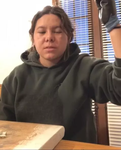 AI Video from prompt: She rolls up her left long sleeve and shows her 