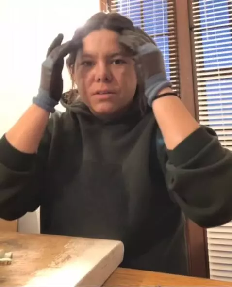 AI Video from prompt: She rolls up both of her hoodie sleeves all the 