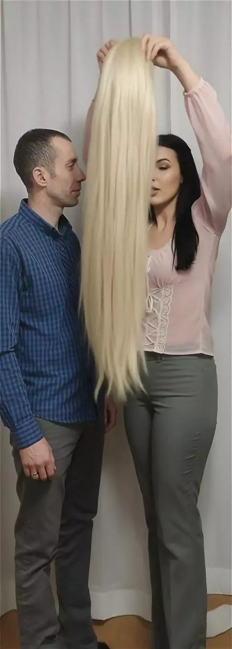 AI Video from prompt: A girl puts on a very long blonde wig with a fri