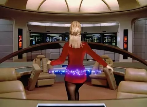 AI Video from prompt: She walks towards the big screen in the bridge a