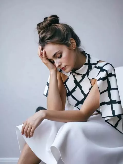 AI Video from prompt: the brooding girl holds her head still  then ope