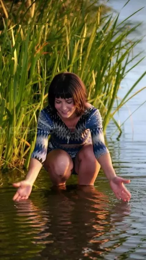 AI Video from prompt: The girl pulls a large moray eel out of the wate