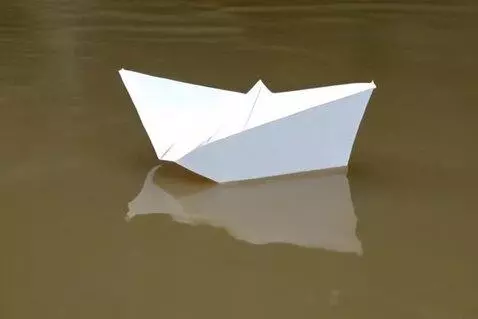 AI Video from prompt: A white paper boat floats on the river. It's lik