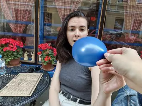 AI Video from prompt: Someone gives a blue balloon to a girl in a vide