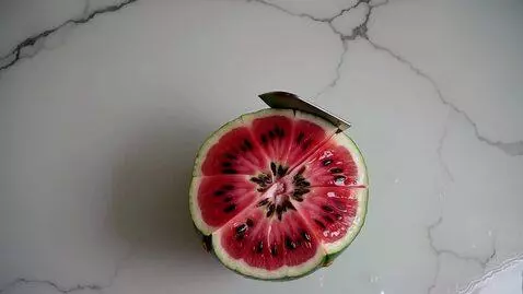 AI Video from prompt: Top-down macro shot of a giant watermelon being 