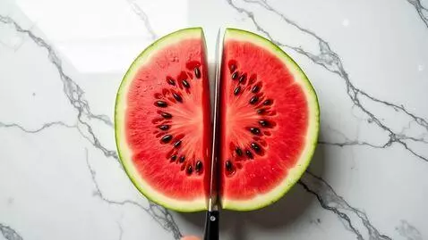 AI Video from prompt: Top-down macro shot of a giant watermelon being 