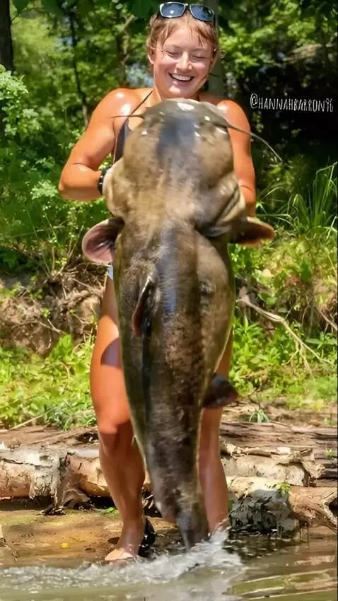 AI Video from prompt: A girl is  holds a huge catfish,which wriggles a