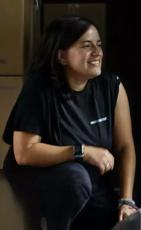 AI Video from prompt: She rolls her left shirt sleeve down and stands 