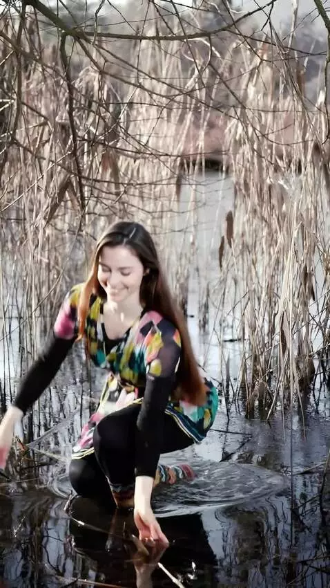 AI Video from prompt: the girl squats down  and catches a large  carp 