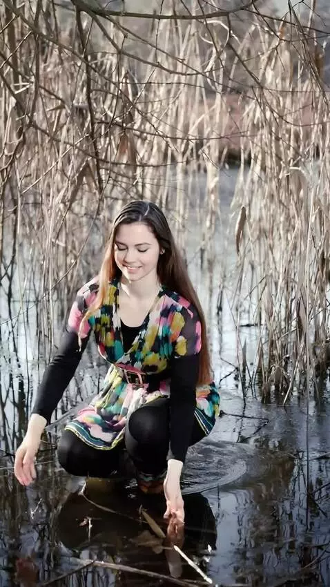 AI Video from prompt: the girl squats down and catches a large,wriggli