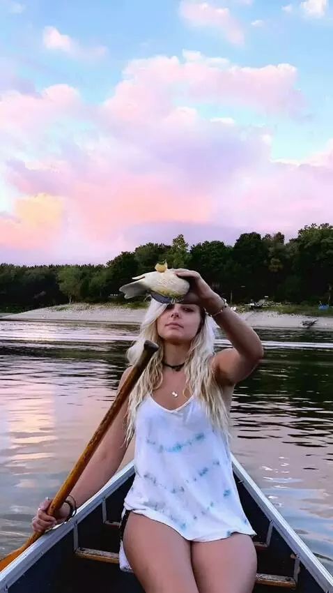 AI Video from prompt: A girl rowing a boat and holding wriggling carp 