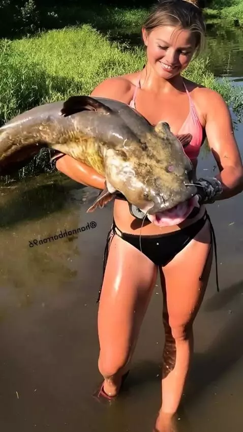 AI Video from prompt: The girl tries to hold the wriggling catfish, bu