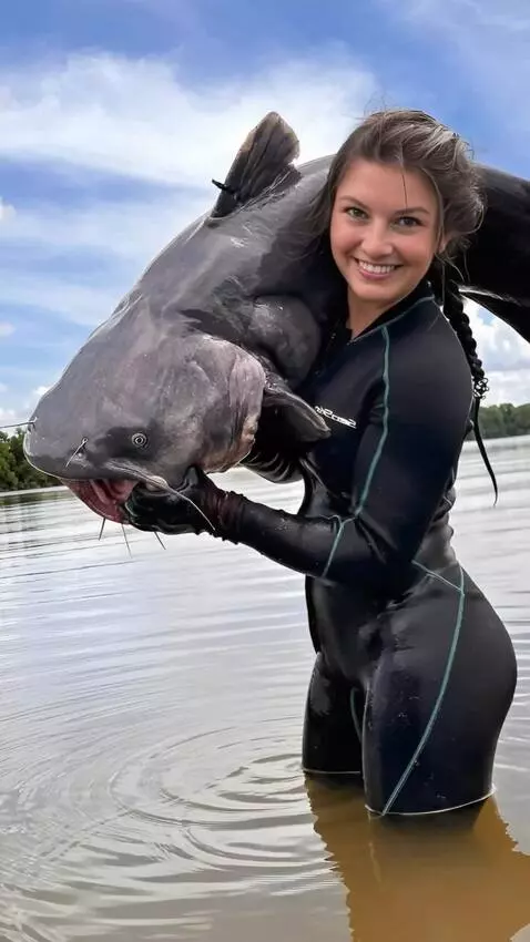 AI Video from prompt: The girl releases the wrighting the catfish into