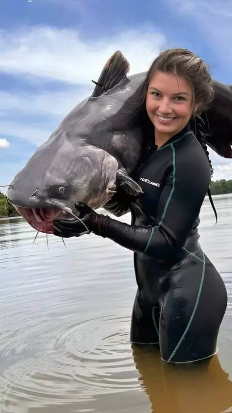 AI Video from prompt: The girl releases the wrighting the catfish into