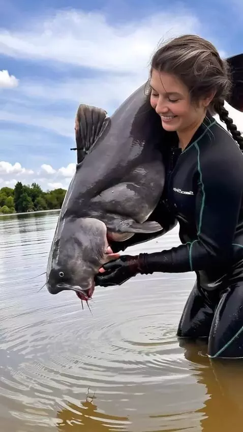 AI Video from prompt: The girl releases the wrighting the catfish into