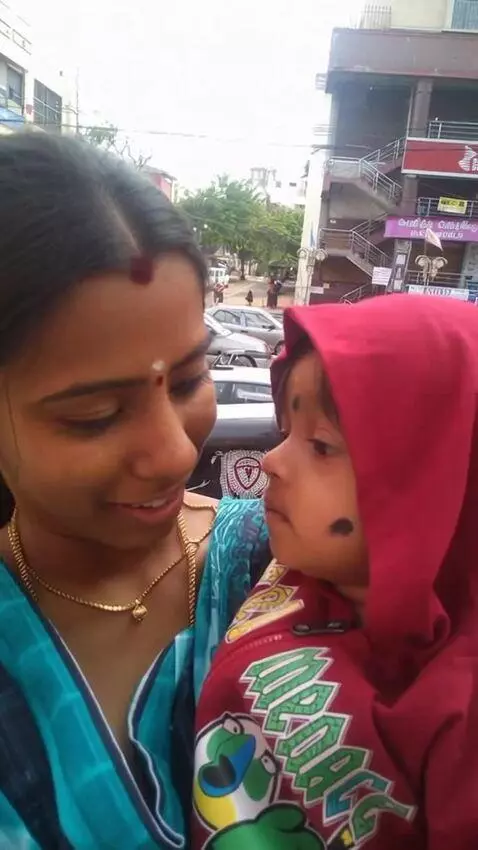 AI Video from prompt: A young Indian mother wearing a green saree hold