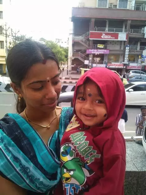 AI Video from prompt: A young Indian mother wearing a green saree hold