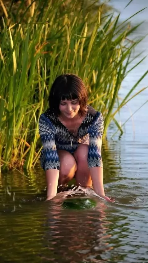 AI Video from prompt: A girl in a skirt takes a large  goliath frog ou