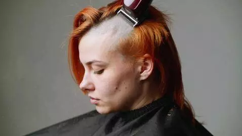 AI Video from prompt: A young woman with straight, thick, fiery red-or