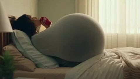 AI Video from prompt: a woman lay on a bed and drink a cola then her b