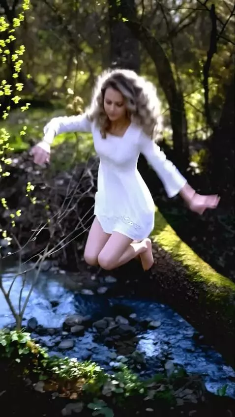 AI Video from prompt: A girl jumps off a log and catches a wriggling m