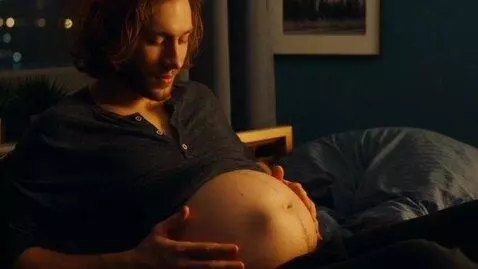 AI Video from prompt: Slender young guy, visibly pregnant with a giant