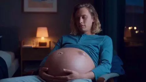 AI Video from prompt: Slender young guy, visibly pregnant with a giant