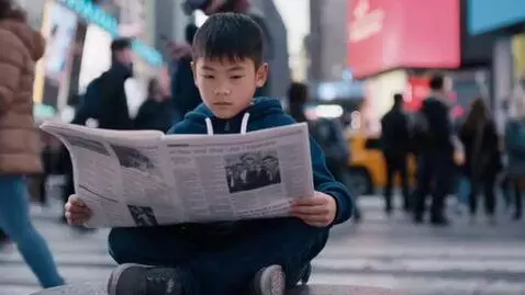 AI Video from prompt: a young asian boy reading a newspaper in time sq