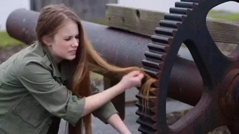 AI Video from prompt: A girl with very long hair that is stuck, she tr