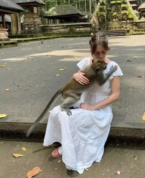 AI Video from prompt: the girl is petting the monkey. her facial expre