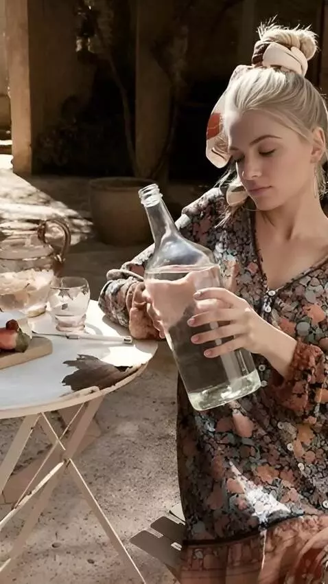 AI Video from prompt: A woman pours water from a large bottle into a g