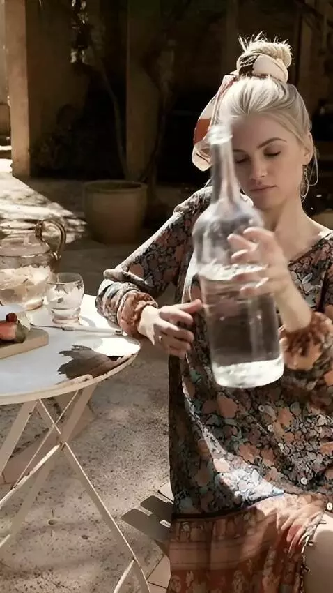 AI Video from prompt: A woman in a skirt  pours water from a large bot