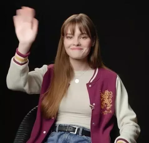 AI Video from prompt: looks directly at the camera and waves hand in g