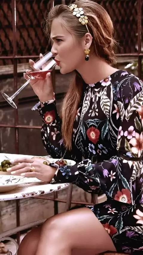 AI Video from prompt: The woman takes a sip from her glass and grimace