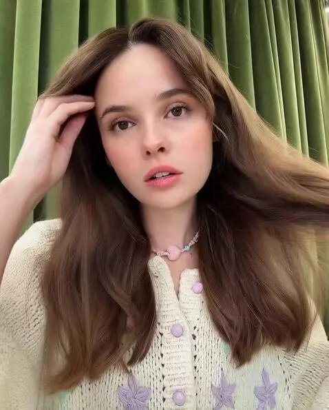 AI Video from prompt: looks directlyat the camera and touches their ha