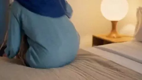 AI Video from prompt: Make her walk into the room, sit on a bed alone,