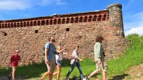 AI Video from prompt: a group of happy Caucasian tourists walks past t