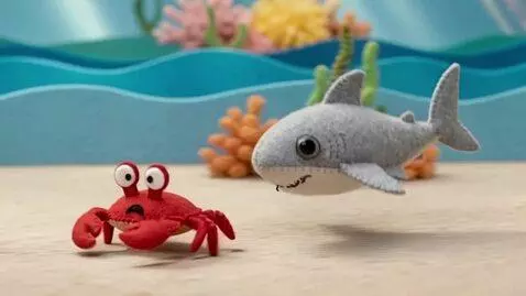 AI Video from prompt: 3D sewn-felt stop-motion style. The tiny shark p