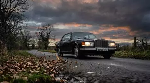 AI Video from prompt: the Rolls Royce drives through the rain in the E